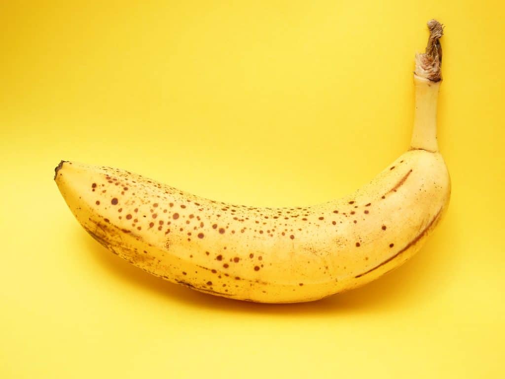 Banaani keltaisella taustalla. Kuva: Lucian Alexe / Unsplash.